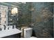 Stylish half bath with modern fixtures, designer wallpaper, mirrored tiles, and a sleek vanity at 3308 Middlesex Rd, Orlando, FL 32803