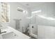 Modern bathroom with dual sinks, glass shower, and decorative tile accents, with bright natural light at 3308 Middlesex Rd, Orlando, FL 32803