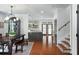 Open hallway connecting dining area and kitchen, featuring decorative tilework on stairs and hardwood floors at 3308 Middlesex Rd, Orlando, FL 32803