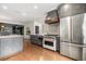 Spacious kitchen with stainless steel appliances, custom range hood, and a large island at 3308 Middlesex Rd, Orlando, FL 32803