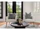 Cozy sitting area with armchairs, a round table, and natural light streaming through the black-framed windows at 3308 Middlesex Rd, Orlando, FL 32803