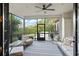 Covered sunroom with tiled flooring and white furniture offering a view of the yard at 3308 Middlesex Rd, Orlando, FL 32803
