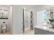 Bright bathroom featuring a shower with blue patterned curtain and white quartz countertop at 4589 Boxwood Way, Mount Dora, FL 32757