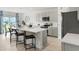 A kitchen island with barstool seating overlooks the dining area with a large window at 4589 Boxwood Way, Mount Dora, FL 32757