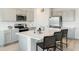 Well-equipped kitchen with stainless steel appliances, light gray cabinets, and a spacious island with barstool seating at 4589 Boxwood Way, Mount Dora, FL 32757