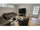 Cozy living room with a plush gray sofa, modern glass coffee table, and sleek entertainment center at 5616 Clearview Dr, Orlando, FL 32819