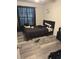 Bedroom with large window, stylish black bed frame, neutral gray wood-style flooring at 5951 Village Cir # Ge, Orlando, FL 32822