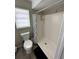 Well-lit bathroom with a walk-in shower, toilet, and window, providing a clean and functional space at 76 Windtree Ln # 201, Winter Garden, FL 34787