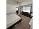 Bright bedroom featuring neutral carpeting, a ceiling fan, and a large window at 76 Windtree Ln # 201, Winter Garden, FL 34787