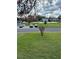 View of parking, grassy area, and community basketball court surrounded by lush landscaping near building at 76 Windtree Ln # 201, Winter Garden, FL 34787