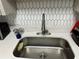 Close-up of the modern kitchen sink with white countertops and stainless steel faucet at 76 Windtree Ln # 201, Winter Garden, FL 34787