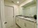 Bright bathroom with double vanity, granite countertop, and large mirror at 8949 Coconut Breeze Dr, Kissimmee, FL 34747