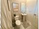 Stylish half bathroom featuring modern fixtures, wallpaper, and tiled flooring at 8949 Coconut Breeze Dr, Kissimmee, FL 34747