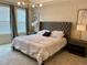 Stylish bedroom with tufted headboard, neutral tones, and ample natural light from the window at 8949 Coconut Breeze Dr, Kissimmee, FL 34747
