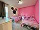 Bright bedroom features two twin beds, Minnie Mouse theme, and a whimsical decor at 8949 Coconut Breeze Dr, Kissimmee, FL 34747