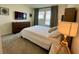 Well-lit bedroom features a dresser, comfortable bed, carpeted floor, and window with blinds at 8949 Coconut Breeze Dr, Kissimmee, FL 34747