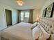 A cozy bedroom featuring a tufted headboard and light colored linens plus art on the walls at 8949 Coconut Breeze Dr, Kissimmee, FL 34747