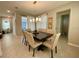 Bright dining area featuring a wooden table, upholstered chairs, and modern lighting at 8949 Coconut Breeze Dr, Kissimmee, FL 34747