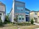 Modern two-story home featuring a blue exterior, stone accents, and well-maintained landscaping at 8949 Coconut Breeze Dr, Kissimmee, FL 34747
