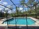 Backyard featuring a pool with safety fence and hot tub surrounded by lush trees and privacy screen at 8949 Coconut Breeze Dr, Kissimmee, FL 34747
