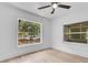 A bright bedroom featuring light hardwood floors, a ceiling fan, and dual windows at 1029 Colyer St, Orlando, FL 32805