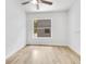 A bright bedroom with wood flooring, a ceiling fan, and a large window at 1029 Colyer St, Orlando, FL 32805