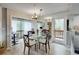 Dining room boasts a glass table, wood chairs, mirrored wall, and slider to balcony with beautiful nature views at 1038 E Michigan St # B, Orlando, FL 32806
