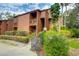 Two-story condo featuring a private balcony, surrounded by lush landscaping and mature trees at 1038 E Michigan St # B, Orlando, FL 32806