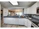 Modern kitchen featuring updated countertops, white cabinets, stainless appliances, and a pass-through to living area at 1038 E Michigan St # B, Orlando, FL 32806