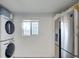 Laundry area featuring stacked washer and dryer, stainless refrigerator and window at 1038 E Michigan St # B, Orlando, FL 32806