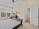 Bedroom with large window, neutral carpet, ceiling fan and ensuite bathroom entrance at 1208 Bella Rose Ct, Davenport, FL 33896