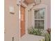 Inviting entryway with decorative light fixture, stylish front door and lush tropical plants at 1208 Bella Rose Ct, Davenport, FL 33896