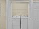 A laundry closet featuring a stacked white washer and dryer, with storage shelves overhead, and a set of bi-fold doors at 1208 Bella Rose Ct, Davenport, FL 33896
