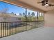 Screened patio area with ceiling fan and railing with views of the community and blue skies at 1208 Bella Rose Ct, Davenport, FL 33896