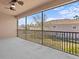 Screened patio area with ceiling fan and railing with views of the community at 1208 Bella Rose Ct, Davenport, FL 33896