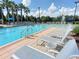 Resort style community pool with plenty of lounge chairs for relaxing in the sun at 1208 Bella Rose Ct, Davenport, FL 33896