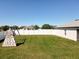Spacious backyard featuring a playground and perimeter white fence at 12524 Garrett Pl, Grand Island, FL 32735