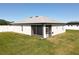 Exterior side view of house and screened in porch showing large fenced yard with green grass at 12524 Garrett Pl, Grand Island, FL 32735