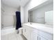 This bathroom features a bathtub with shower, white vanity, and gray tile flooring at 12524 Garrett Pl, Grand Island, FL 32735