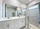 Bathroom features double sink vanity, tiled floor and glass shower at 12524 Garrett Pl, Grand Island, FL 32735