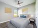 Bedroom featuring a ceiling fan, wood-look floors, window, and neutral paint at 12524 Garrett Pl, Grand Island, FL 32735
