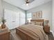 Bedroom with wood-look floors, a ceiling fan, a window, and neutral paint at 12524 Garrett Pl, Grand Island, FL 32735