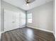Bedroom featuring wood-look floors, a ceiling fan, and a double-door closet at 12524 Garrett Pl, Grand Island, FL 32735