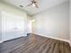 Bedroom featuring a ceiling fan, wood-look floors, and double-door closet at 12524 Garrett Pl, Grand Island, FL 32735