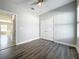Bright bedroom featuring wood-look floors, a ceiling fan, and double closet doors at 12524 Garrett Pl, Grand Island, FL 32735