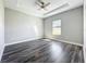Bright bedroom features wood-look floors, ceiling fan and tray ceiling at 12524 Garrett Pl, Grand Island, FL 32735