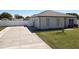 View of the driveway leading to the garage with a well-manicured lawn at 12524 Garrett Pl, Grand Island, FL 32735