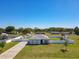 Charming single-story home features a white fence, a long driveway, and a well-manicured lawn at 12524 Garrett Pl, Grand Island, FL 32735
