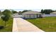 Angle view of home, showcasing driveway, vinyl fence, landscaping, and two car garage at 12524 Garrett Pl, Grand Island, FL 32735