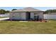 Home exterior with green lawn, tidy landscaping, and walkway leading to the entrance at 12524 Garrett Pl, Grand Island, FL 32735